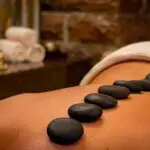 Heated stones placed on a client’s back during a massage session.