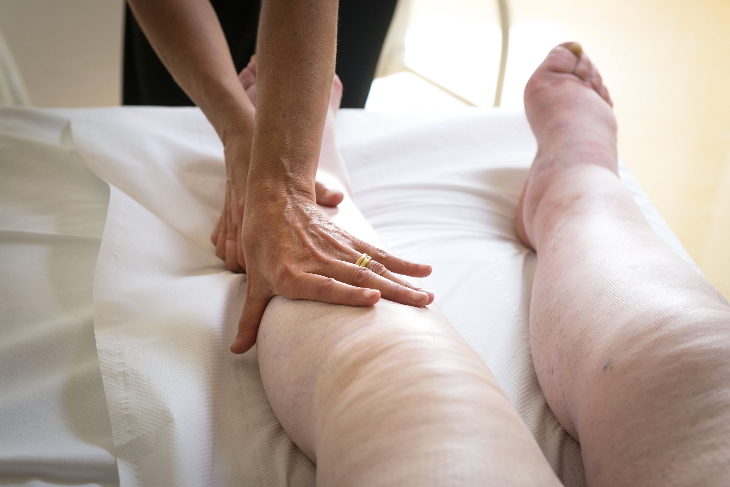 A person is getting their leg waxed on the bed